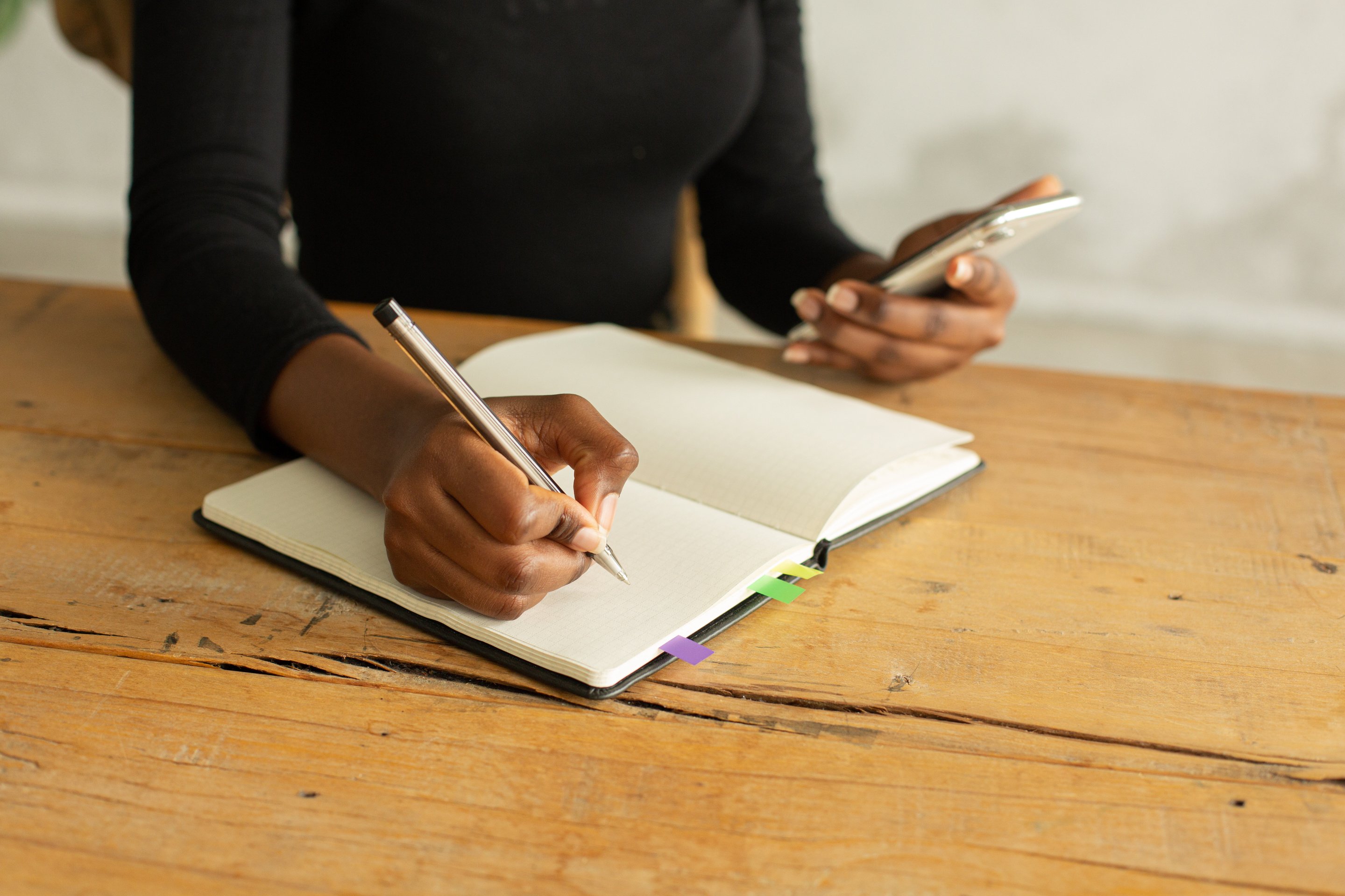 Person in Black Long Sleeve Shirt Writing on White Paper